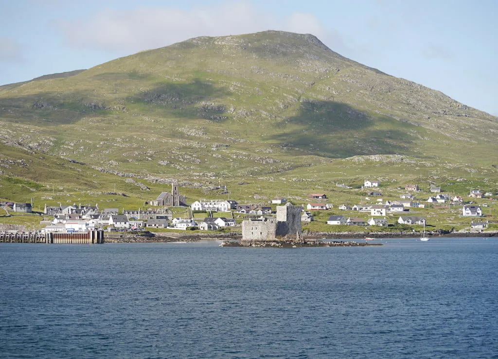 The Village of Castlebay from the sea with Kisimul Castle in the foreground and Heaval beyond